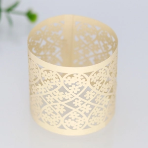Macro detail of laser-cut heart and floral lace patterns on beige paper napkin ring