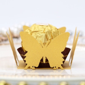 Macro shot of laser-cut gold butterfly paper decoration for chocolates and candy