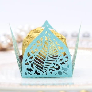 Macro detail of sky blue laser-cut paper chocolate wrapper with hollow leaf pattern