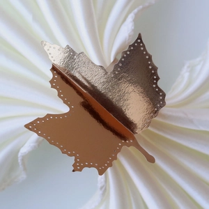 Macro detail of copper-gold maple leaf napkin ring with decorative hollow edge