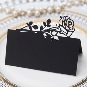 Detail of laser-cut black rose place card for weddings with elegant hollowed floral design