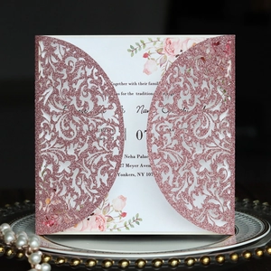 Détail d'invitation de mariage découpée au laser pailletée or rose avec carte florale