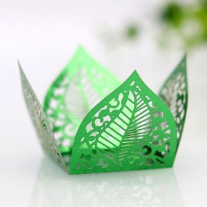 Detailed laser-cut green paper favor box with intricate hollow leaf patterns