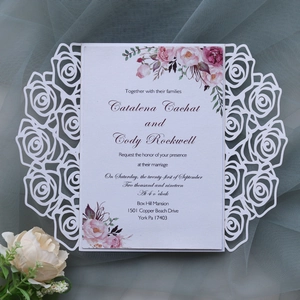 Detail of laser-cut rose hollow wedding invitation with colorful floral inner card