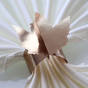 Close-up of rose gold leaf napkin ring with intricate laser-cut edges and metallic shine