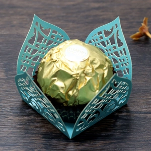 Close-up of laser-cut teal paper candy holder with intricate geometric petal pattern