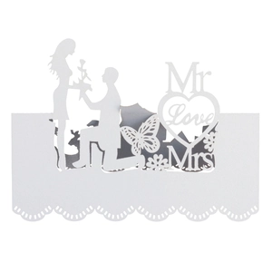 Close-up of white laser-cut wedding place card with romantic silhouette and butterfly