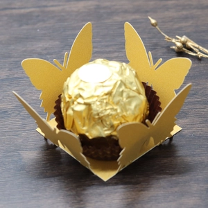 Detailed view of laser-cut gold butterfly paper candy wrapper with hollow lace design