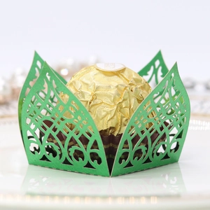 Macro detail of laser-cut green paper wedding favor holder for chocolate candy