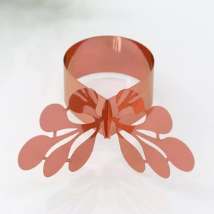 Close-up of rose gold napkin ring featuring an intricate laser-cut butterfly design