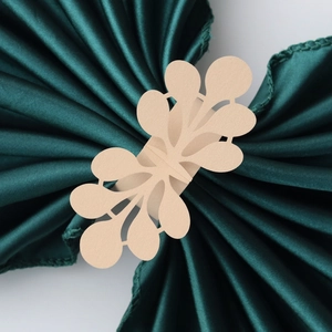 Detail of laser-cut gold pearlescent paper napkin ring with elegant leaf pattern