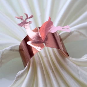 Macro detail of rose gold reindeer napkin ring with mirrored finish for Christmas tables