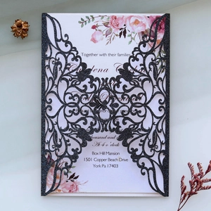 Détail de l'invitation de mariage noire pailletée découpée au laser avec motif de fleurs