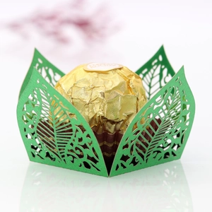 Macro detail of laser cut hollow leaf design on green wedding chocolate paper holder