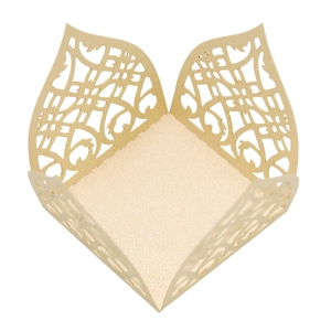Close-up of laser-cut champagne gold pearlescent paper candy box with scroll pattern
