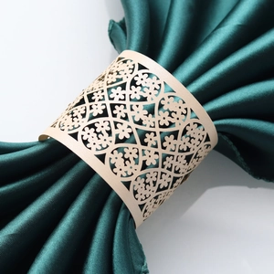 Close-up of laser-cut pearl paper napkin ring with intricate floral lace pattern