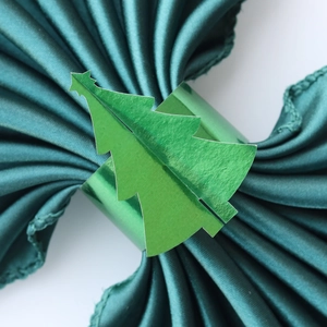 Macro d'un rond de serviette sapin de Noël vert sur tissu satiné pour table festive