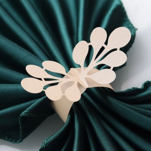 Detail of laser-cut gold pearlescent paper napkin ring with floral lace patterns