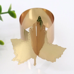Detailed macro of golden mirror finish leaf napkin ring with hollow circular edge design