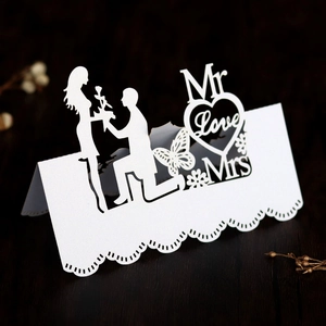 Detailed laser-cut white heart place card with butterfly and silhouette for wedding table