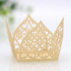 Detailed laser-cut crown cupcake wrapper in champagne gold for elegant party decor
