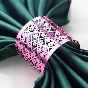 Macro view of metallic pink napkin ring with intricate hollow floral lace patterns