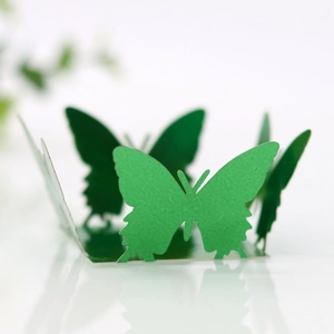 Detailed close-up of 3D emerald green butterfly cutout with mirrored reflection