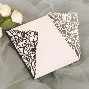 Détail d'invitation de mariage découpée au laser avec motifs floraux pailletés dorés