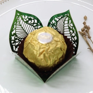 Macro detail of laser-cut green leaf chocolate holder with metallic paper texture