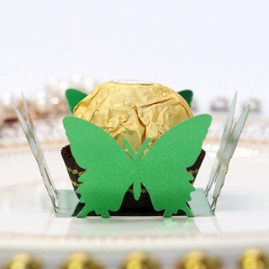 Close-up of laser-cut grass green butterfly paper candy holder with hollow details