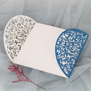 Détails de motifs floraux découpés au laser sur une invitation crème et paillettes bleues