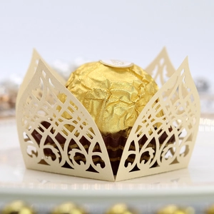 Detailed macro view of laser-cut ivory decorative paper wrapper for wedding chocolates