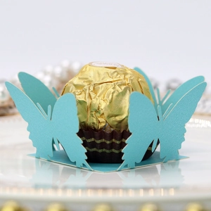 Macro view of laser-cut light blue butterfly candy holder for wedding chocolate decoration