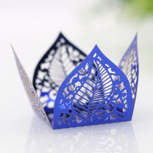 Detailed macro view of laser-cut blue lace paper wrapper with hollow leaf and floral patterns