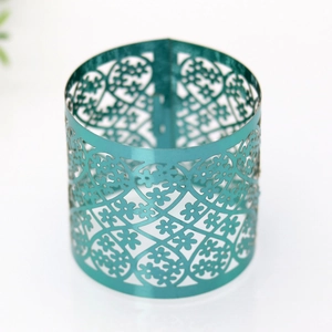 Close-up of golden laser-cut metal napkin ring with intricate floral lace patterns