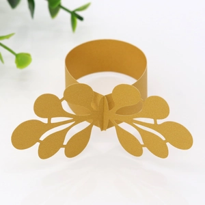 Elegant gold pearlescent paper napkin ring with laser-cut hollow leaf design for weddings