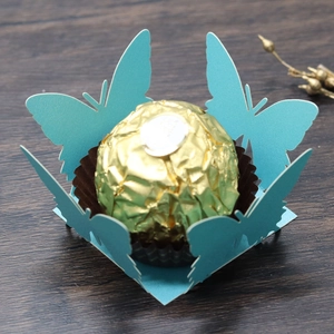 Close-up of laser-cut butterfly candy box in sky blue with golden chocolate decoration