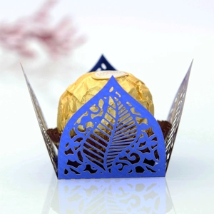 Intricate laser-cut navy blue chocolate wrapper with hollow leaf pattern on mirror surface