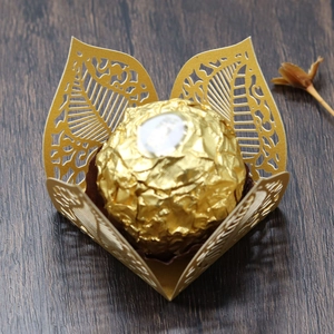 Detail of laser-cut gold hollow leaf candy box with elegant filigree paper texture