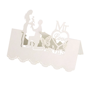 Laser cut white wedding place card featuring Mr and Mrs butterfly heart silhouette