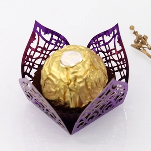 Detail of laser-cut purple metallic paper candy wrapper with intricate floral hollow pattern