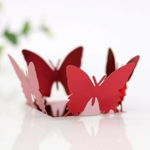 Detailed laser-cut butterfly cupcake wrappers in glossy red and pink paper for party