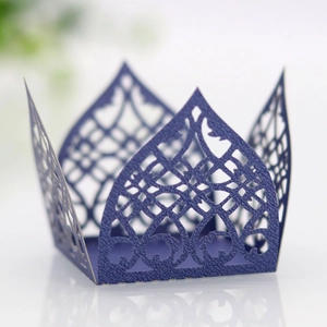 Macro detail of laser cut purple pearlescent paper cupcake wrapper with floral pattern