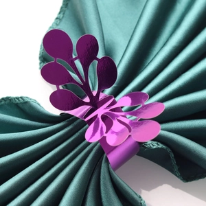 Detailed view of purple iridescent laser-cut napkin ring with ornate leaf design