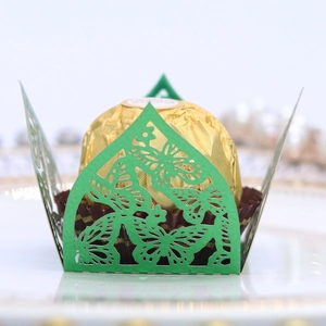 Macro view of laser-cut green butterfly candy box with hollow decorative pattern