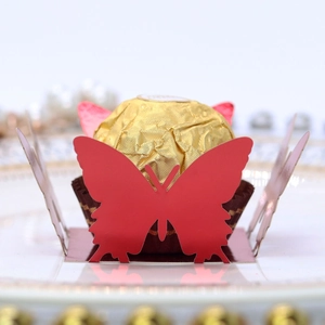 Macro shot of red laser-cut butterfly wrapper for chocolate on a white plate
