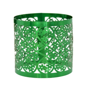 Detail of emerald green metal napkin ring featuring intricate laser-cut floral patterns