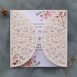 Détail d'un faire-part de mariage pailleté découpé au laser avec intérieur floral élégant