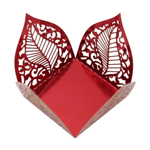 Detailed macro view of laser-cut red metallic hollow leaf patterns on the candy gift box