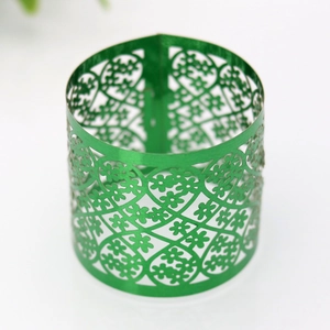 Detail of green laser-cut floral pattern napkin ring with intricate hollow lace texture